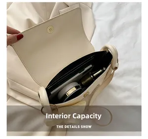 Internal capacity of beige leather shoulder bag showing storage for makeup and cards