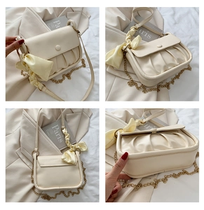 Detailed views of creamy pleated cloud bag with gold chain and stylish silk scarf