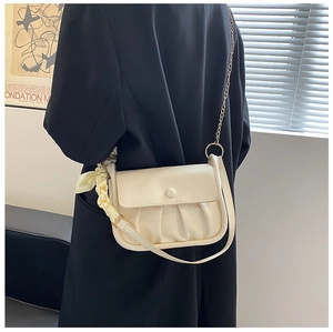 Detail of off-white ruched cloud bag with silk scarf handle and golden chain strap