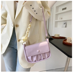 Detail of light purple pleated cloud bag with stylish cream fabric shoulder ornament