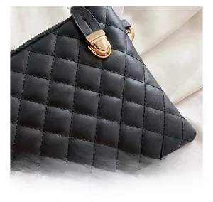 Detail view of black quilted PU leather texture with gold metal turn-lock closure