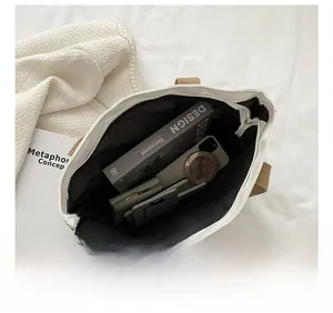 Overhead view showing large capacity interior of off-white canvas tote with brown straps