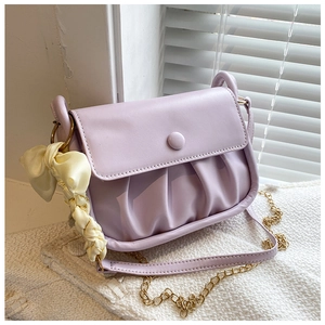 Detail of lavender ruched cloud bag with yellow silk bow and gold chain strap