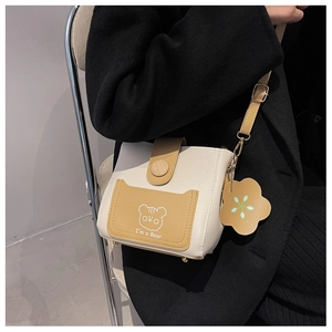Detail of Korean bucket bag featuring bear print and flower charm on faux leather