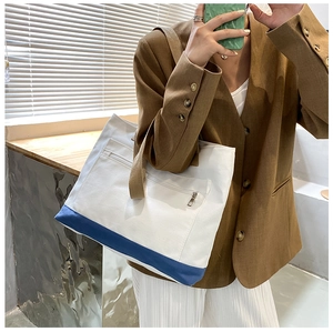 Close-up of canvas tote bag with front zipper pocket and contrast blue bottom detail