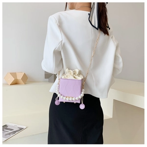 Detail of light purple bucket bag with pearl handle and wave pattern on model