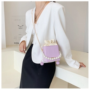 Detail view of purple bucket bag featuring water ripple texture and pearl handle