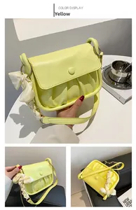Detail view of yellow pleated cloud shoulder bag with decorative silk scarf and gold hardware