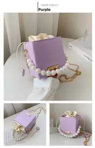 Detail of purple bucket bag with pearl handle and wave textured synthetic leather