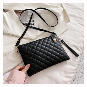 Close-up of black quilted PU leather shoulder bag with golden hardware and luxury texture