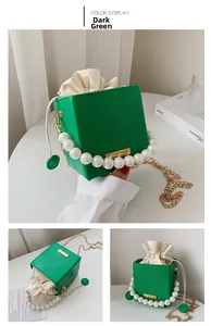 Detail of emerald green bucket bag with pearl handle, ripple texture and drawstring closure