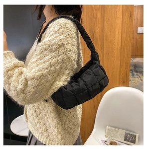 Dettaglio di una borsa a tracolla trapuntata nera in nylon con trama soffice e ampia