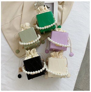 Detailed overhead view of bucket bags in five colors with pearl handles and wavy texture