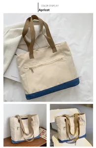 Detail of large beige canvas tote bag with navy blue base and brown ribbon handles
