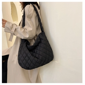 Dettaglio di una borsa a tracolla nera trapuntata che mostra la trama del nylon di lusso