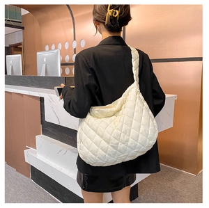 Vista laterale dettagliata di una grande borsa hobo bianca trapuntata con texture morbida