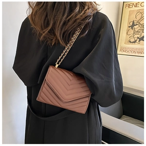 Vue détaillée du sac bandoulière matelassé marron foncé avec chaîne dorée et rabat en V