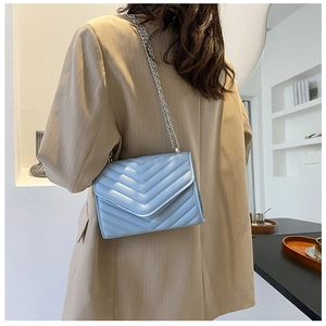 Détail du sac bandoulière bleu clair avec matelassage chevron et chaîne dorée