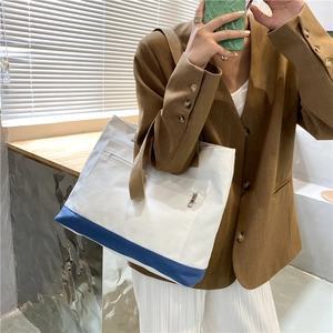 Minimalist canvas tote bag with contrast blue bottom panel and khaki shoulder straps