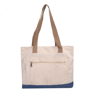 Large beige and navy canvas tote bag with brown straps and front zipper pocket