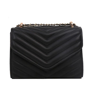 Sac bandoulière noir matelassé avec chaîne dorée et motif en V sur fond blanc pur
