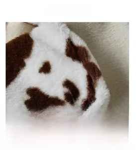 Close-up of the plush cow print fabric with thick, soft faux fur texture and detailed fibers