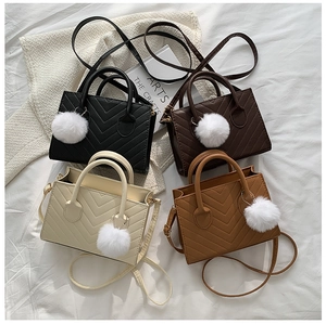 Collection of V-quilted faux leather crossbody bags with plush pom-pom charms in four colors