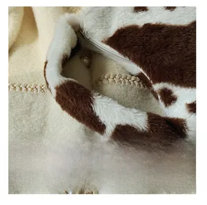 Detail of soft faux fur cow print tote bag with comfortable handle and zipper closure