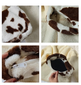 Detail of cow print faux fur tote with smooth zipper and durable inner lining