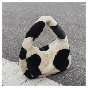 Vue détaillée du cabas en peluche à motif vache avec fermeture éclair et texture douce