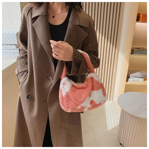 Detail of pink cow-print plush tote bag showing soft faux fur texture and handle