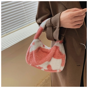Detail of pink and white cow print plush tote bag with soft faux fur texture for winter