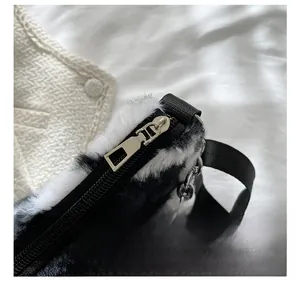 Close-up of silver metal zipper and soft cow print faux fur texture on the bag
