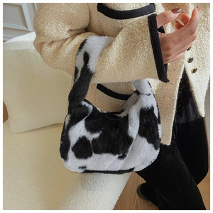 Close-up of black and white cow print faux fur tote bag with plush soft texture