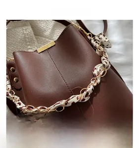 Détail du sac en cuir marron foncé avec boucle dorée et bandoulière imprimé léopard
