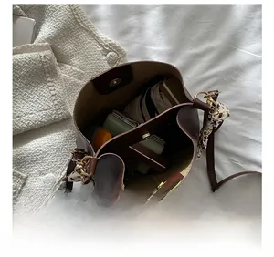 Vue intérieure du sac seau marron foncé montrant sa grande capacité pour un portefeuille