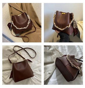 Détail du sac seau marron vintage avec chaîne dorée et poignée en foulard de soie