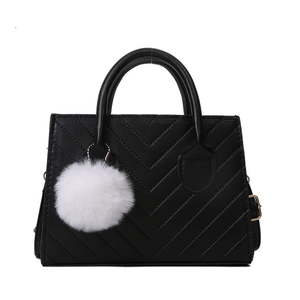 Chic black chevron quilted crossbody bag with white pompom charm and top handles