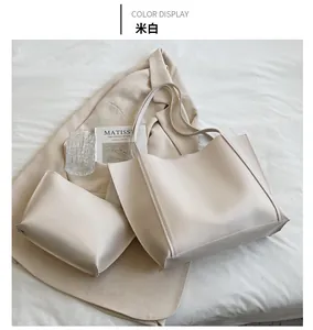 Detail of minimalist cream PU leather tote bag set including a small matching pouch
