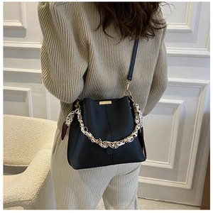 Détail du sac seau noir avec poignée en foulard léopard et garnitures dorées