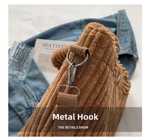 Detail of silver metal hook and textured brown corduroy fabric on a casual tote bag