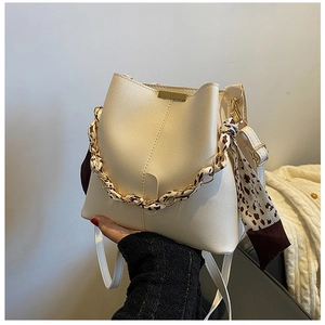 Détail du sac seau blanc crème avec foulard léopard sur la bandoulière dorée
