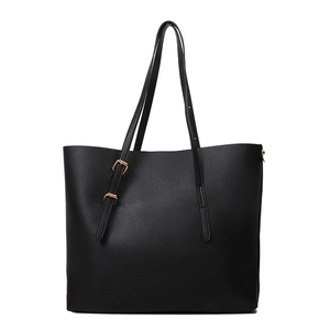 Minimalist black faux leather tote bag with gold buckle detail and long shoulder straps