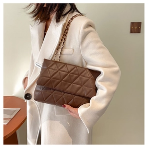 Détail du sac à bandoulière en cuir matelassé marron foncé avec chaîne dorée