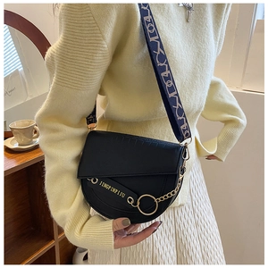 Details der schwarzen Satteltasche mit Krokoprägung, breitem Gurt und Goldakzenten