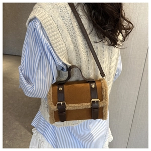 Details der braunen Lammfell-Tasche mit flauschigem Rand und goldenen Schnallenriemen