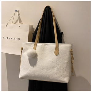 Detail of white tote bag with cartoon embossed patterns and white plush pom-pom charm