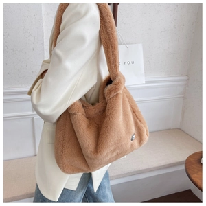 Detailed view of the brown plush shoulder bag with fluffy faux fur and silver logo tag