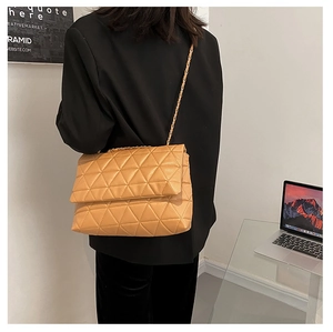 Détail du sac bandoulière matelassé kaki avec coutures triangles et chaîne