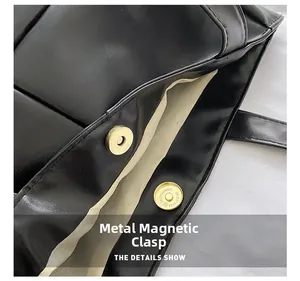 Detail of golden magnetic buckle on black woven tote bag with soft light beige lining